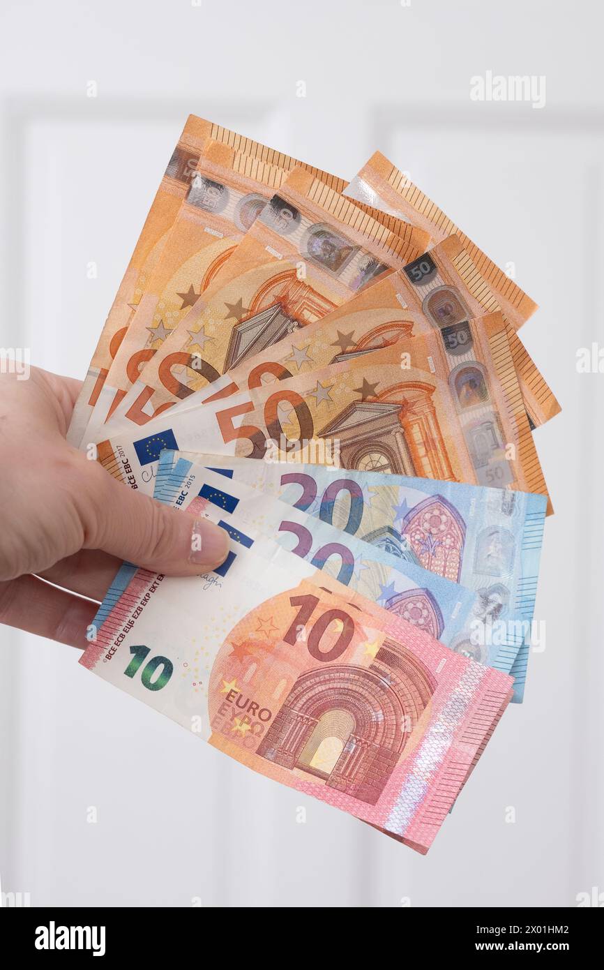 Mano che trattiene le banconote in euro Foto Stock