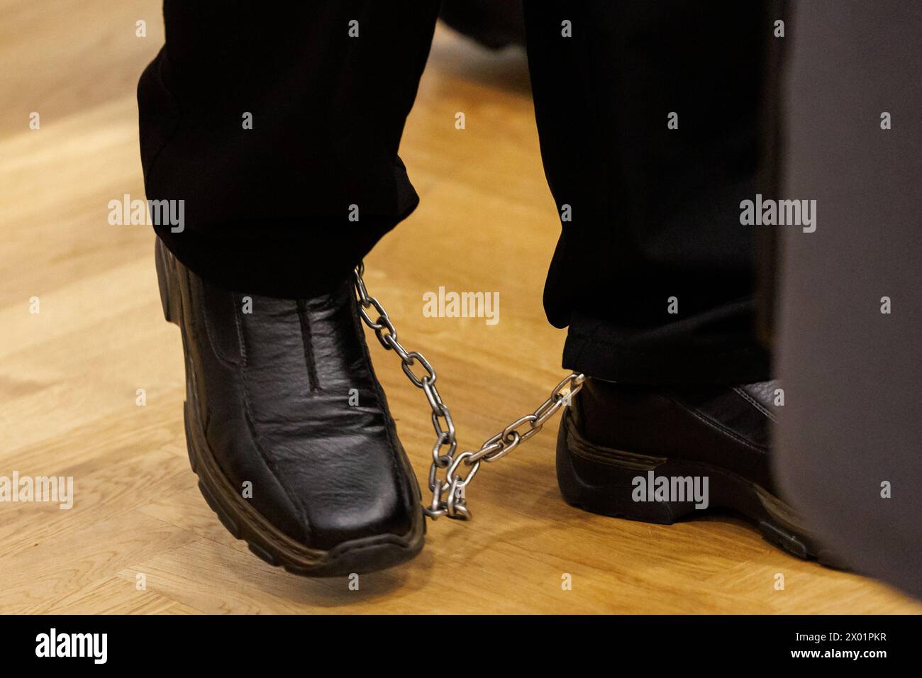 Norimberga, Germania. 09 aprile 2024. Un uomo sotto processo per omicidio arriva all'inizio del processo nel tribunale distrettuale di Norimberga-Fürth con le catene. Nel dicembre 2022, una donna fortemente incinta di Norimberga scompare senza lasciare traccia. Anche se il suo corpo non è ancora stato trovato, gli investigatori ipotizzano che la donna di 39 anni sia stata rapita e uccisa dal suo ex partner e dal suo socio in affari. Le accuse contro i due accusati, di 50 e 48 anni, sono omicidio e sequestro di ostaggi. Crediti: Daniel Karmann/dpa/Alamy Live News Foto Stock