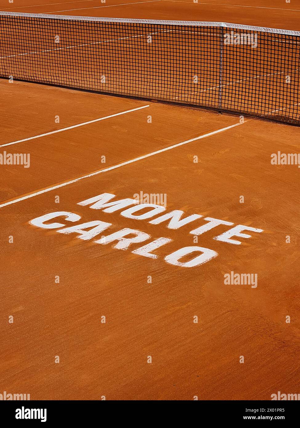 Vista ravvicinata del caratteristico campo di argilla arancione del prestigioso torneo di tennis Monte-Carlo Masters, caratterizzato da linee bianche e rete Foto Stock