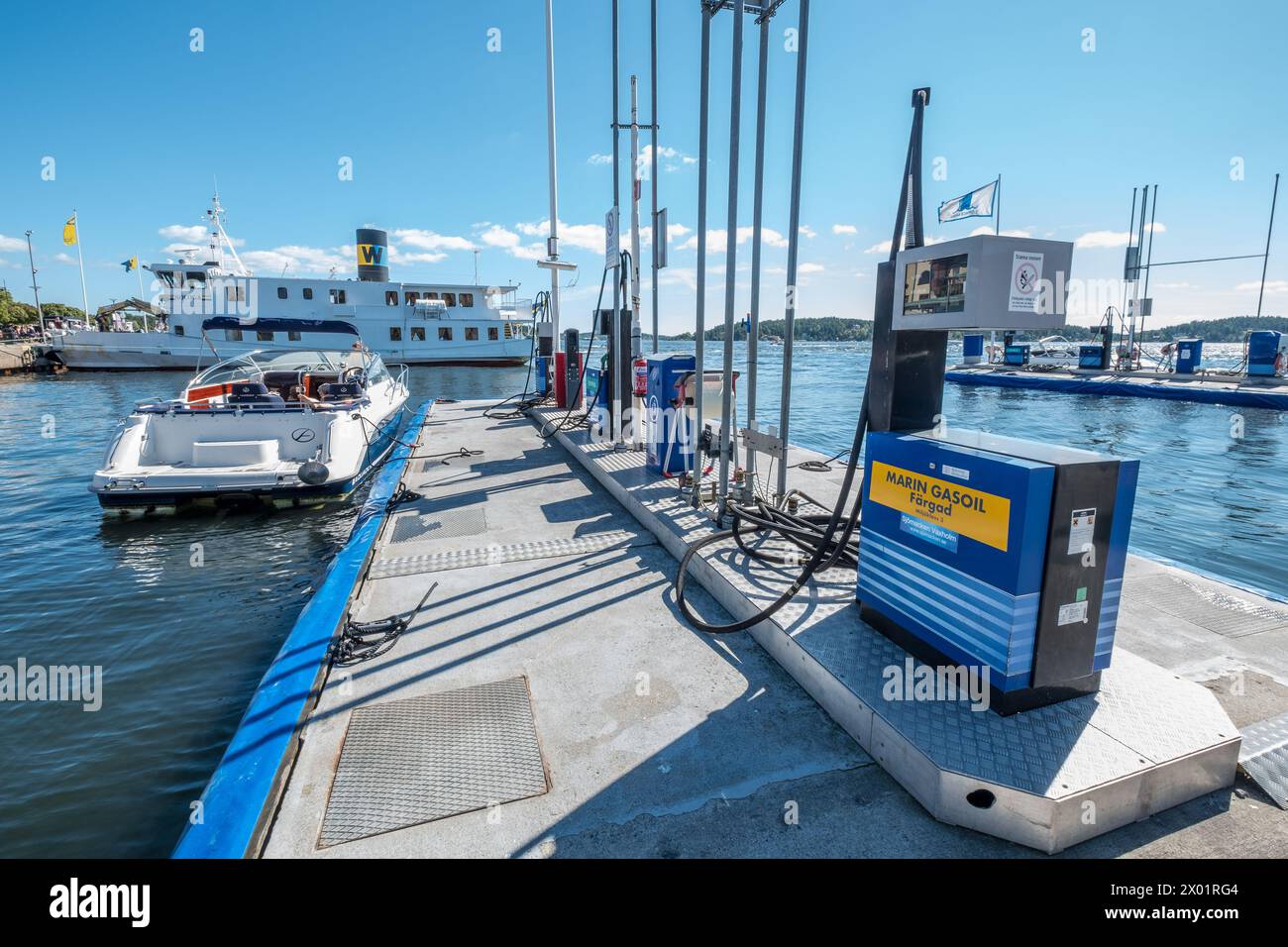 VAXHOLM, SVEZIA - 11 AGOSTO 2018: Un motoscafo ormeggiato in una stazione di servizio galleggiante si prepara a prendere il carburante in porto in una giornata estiva di sole. Foto Stock