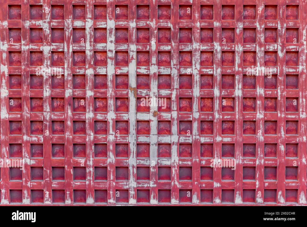 parete rossa in legno invecchiato con un caratteristico motivo a griglia Foto Stock