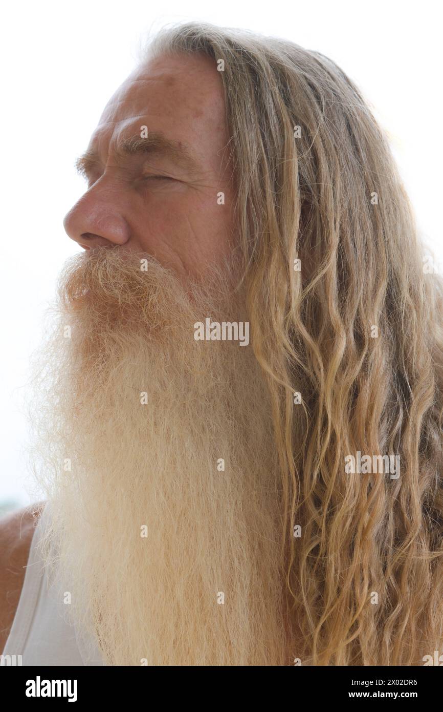 Un ritratto di un uomo barbuto anziano con i capelli lunghi e gli occhi chiusi Foto Stock