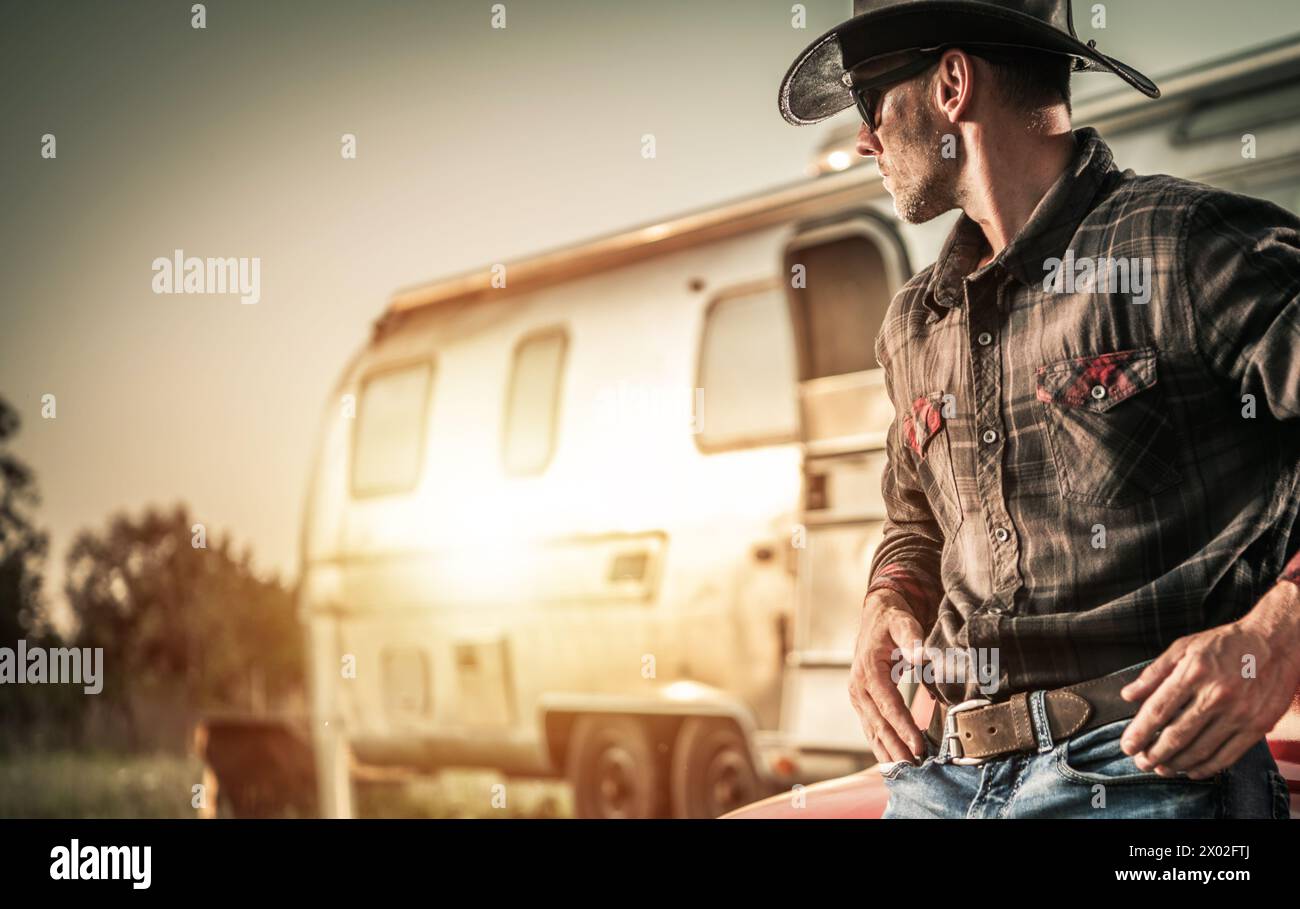 Cowboy caucasico americano a 40 anni e il suo Ranch durante il tramonto panoramico Foto Stock
