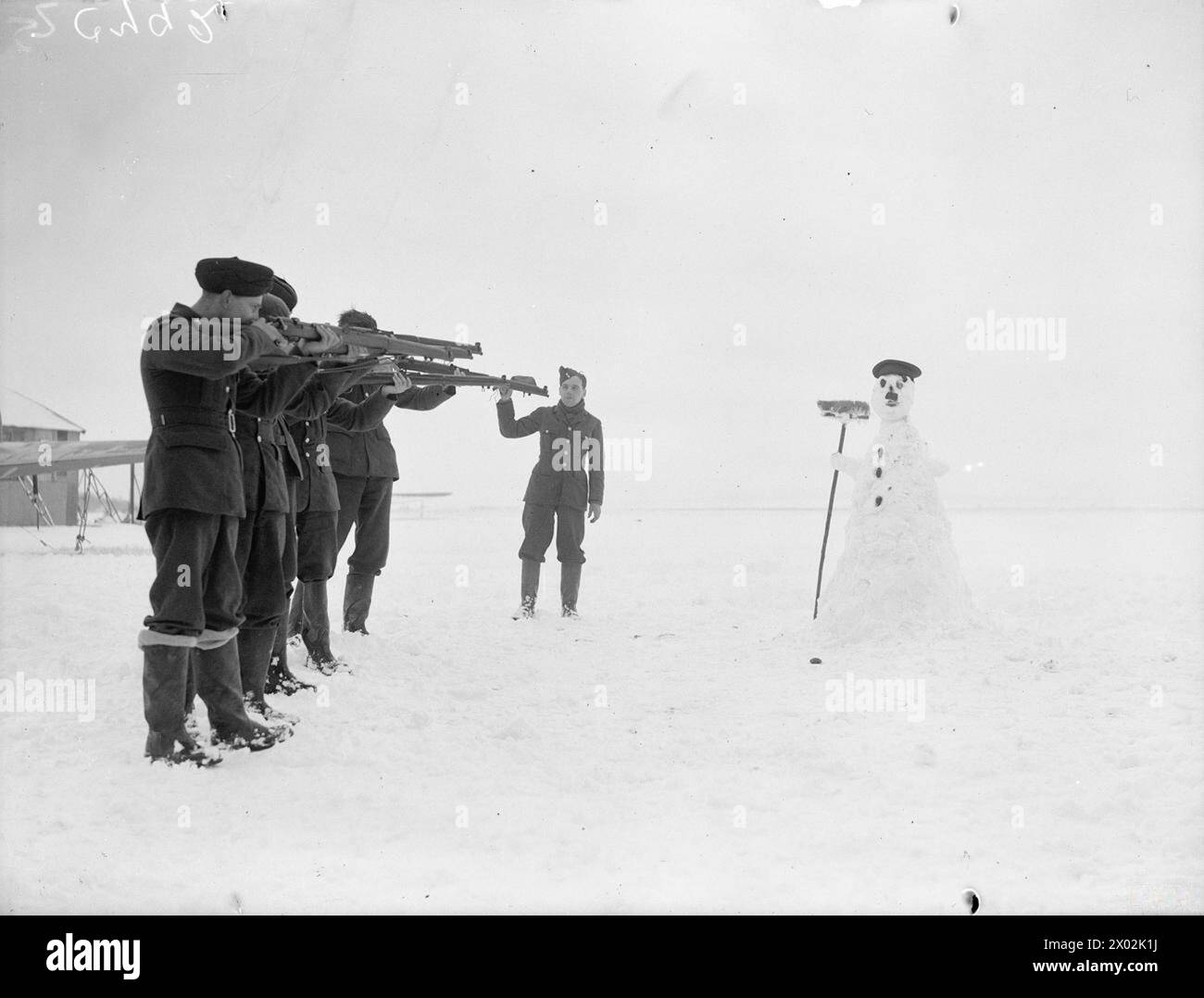 Il personale della RAF in Francia, innevato durante l'inverno, pratica puntando a un pupazzo di neve a forma di Hitler, mantenendo le abilità in condizioni avverse. Foto Stock