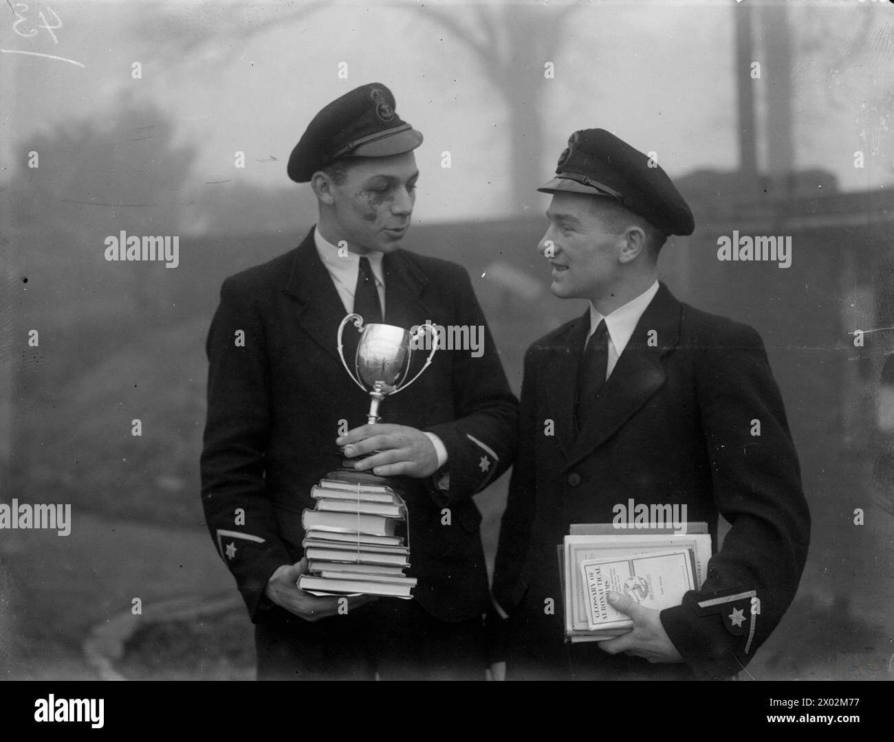 IL QUINTO SIGNORE DEL MARE ISPEZIONA GLI APPRENDISTI AEREI NAVALI E REGALA PREMI. 12 E 13 DICEMBRE 1944, HMS DAEDALUS II, ROYAL NAVAL AIR STATION, NEWCASTLE-UNDER-LYME. VICE AMMIRAGLIO D W BOYD, CB, CBE, DSC, QUINTO SIGNORE DEL MARE, ISPEZIONE DEGLI APPRENDISTI AEREI DELLA MARINA. - A sinistra: Chief Petty Officer Naval Air Apprentice K T Martin, di Plymouth con i premi e la coppa che ha vinto come capitano della squadra di rugby, e (a destra) Chief Petty Officer Naval Air Apprentice R L Routledge, di Carlisle con i premi vinti durante l'esame di superamento Foto Stock