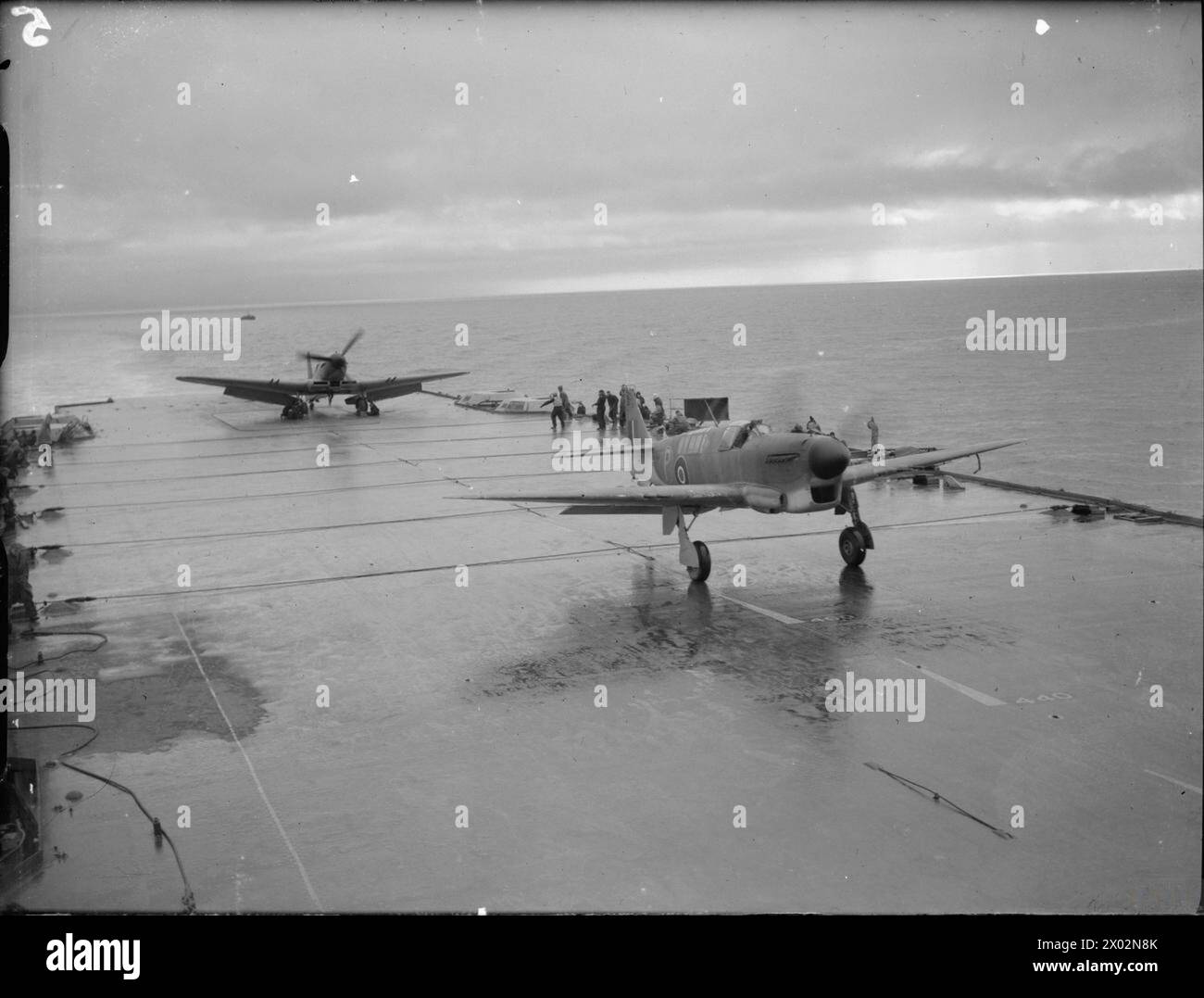 LA ROYAL NAVY DURANTE LA SECONDA GUERRA MONDIALE - il Fairey Firefly, caccia a lungo raggio a due posti che decolla dal ponte di volo della HMS ILLUSTRIOUS sul Clyde. Il Fairey Firefly l'ultimo aereo della Royal Navy, è un caccia a lungo raggio a due posti, progettato per essere utilizzato dalle portaerei come aereo da ricognizione pesantemente armato. Un Blackburn Firebrand può essere visto all'estremità della cabina di volo con il suo motore in funzione Royal Navy, HMS Illustrious, portaerei, (1939) Foto Stock