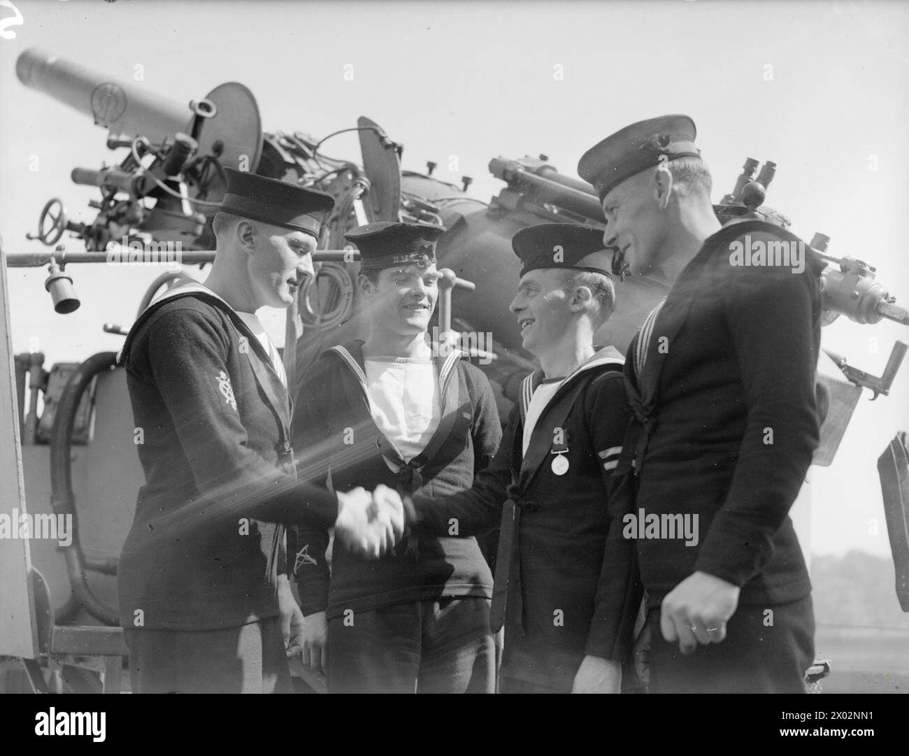L'Able Seaman Lawrence Hodgson del dragamine Halcyon, all'età di 30 anni da Liverpool, ha ricevuto la medaglia RNVR per il lungo servizio e la buona condotta il 28–29 giugno 1943 a Londonderry, congratulato con i compagni di nave. Foto Stock