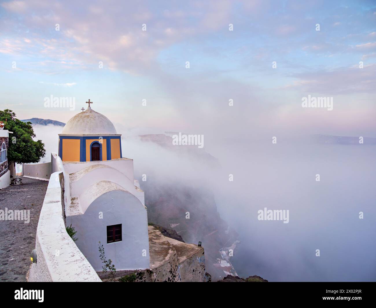 Chiesa di San Stylianos all'alba nebbiosa, Fira, isola di Santorini (Thira), Cicladi, isole greche, Grecia, Europa Foto Stock