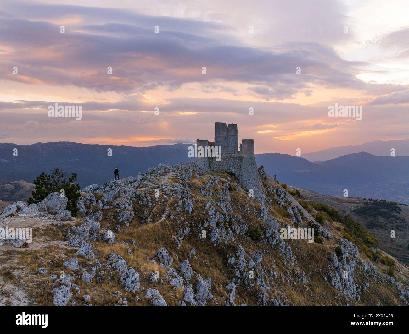 Una persona ammira il castello di Rocca Calascio durante l'alba autunnale, il Parco Nazionale del Gran Sasso e Monti di Laga, Abruzzo, Italia, Europa Foto Stock