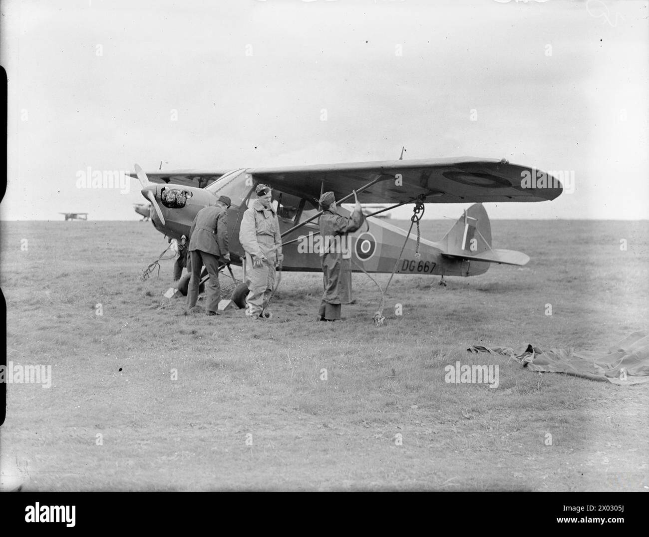 Nel febbraio 1941 a Larkhill, Wiltshire, il Piper Cub DG667 del No. 651 (AOP) Squadron RAF è assicurato con picchetti da parte dell'equipaggio di terra dopo essere stato impressionato dal registro civile. Foto Stock
