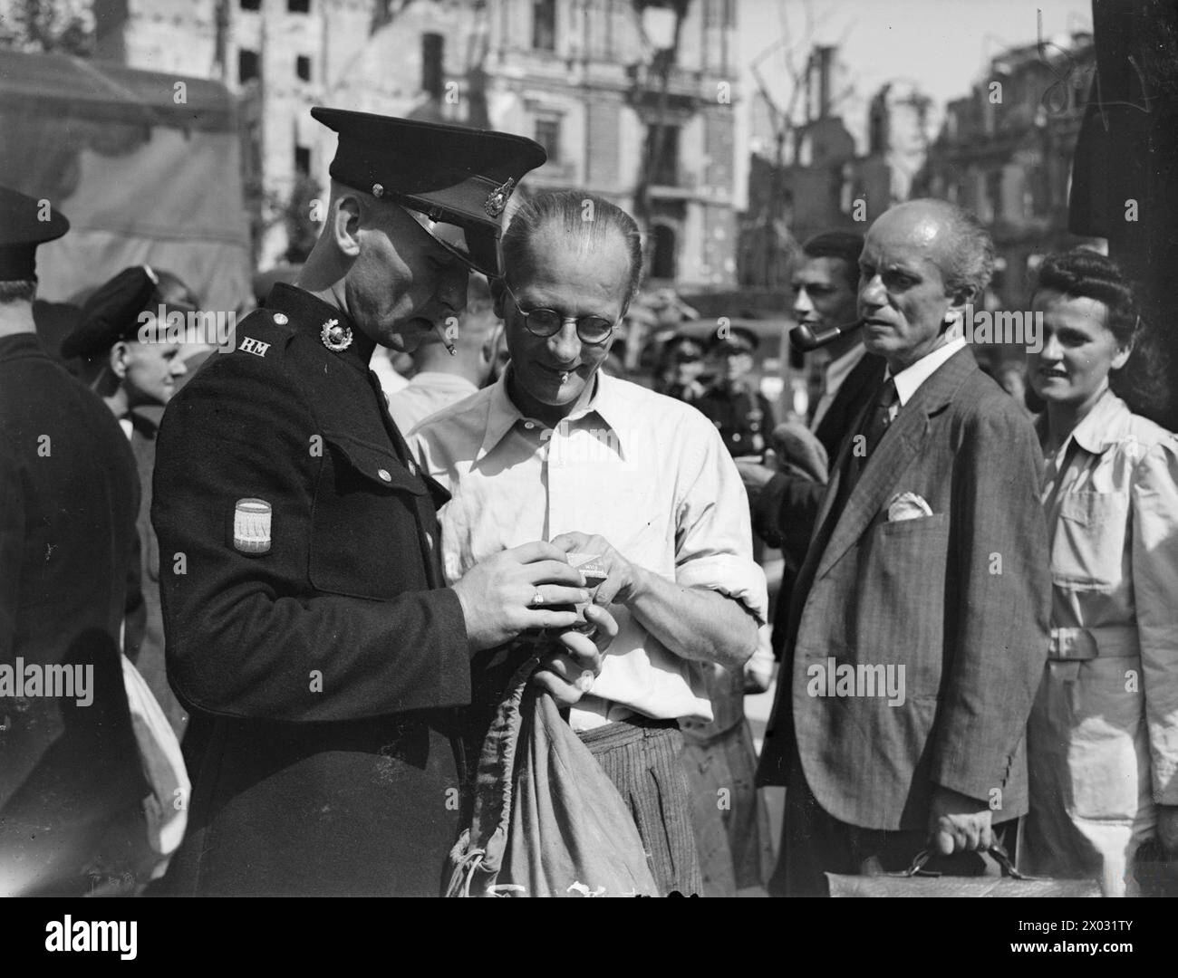 UOMINI DELLA ROYAL NAVY E DEI ROYAL MARINES A BERLINO. LUGLIO 1945, DURANTE UNA VISITA A BERLINO DEGLI UOMINI DELLA ROYAL NAVY E DEI ROYAL MARINES. - Un Royal Marine che compra un film per la sua macchina fotografica da un commerciante tedesco vicino alla Cancelleria Foto Stock