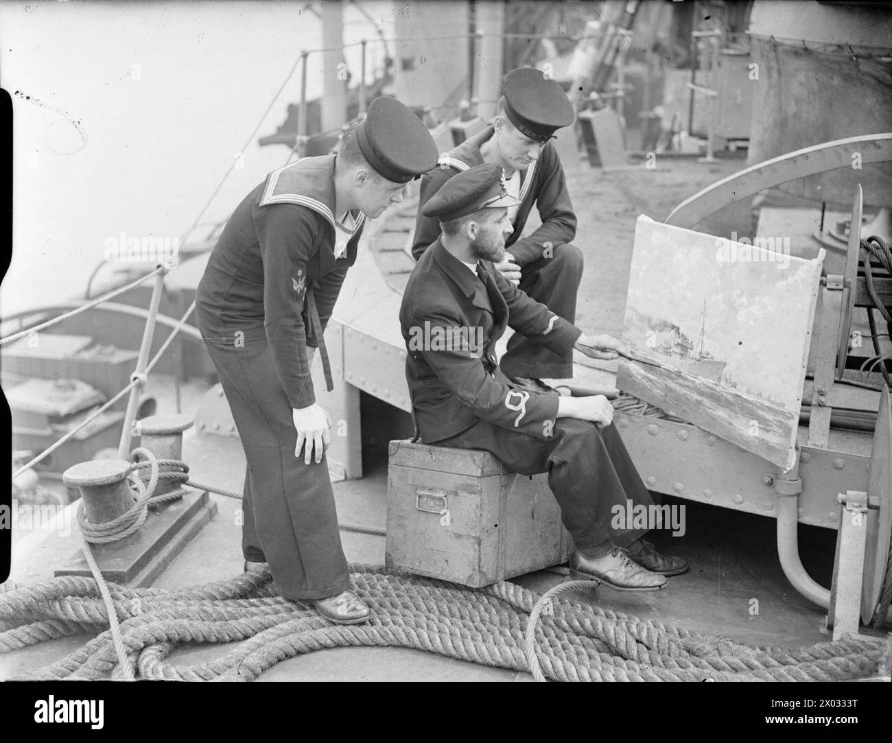 I membri dell'equipaggio della HMT Greenfly osservano il sottotenente Daniels che dipinge un ritratto di una nave della Royal Navy a bordo del peschereccio a Harwich durante la seconda guerra mondiale Foto Stock I membri dell'equipaggio della HMT Greenfly osservano il sottotenente Daniels che dipinge un ritratto di una nave della Royal Navy a bordo del peschereccio a Harwich durante la seconda guerra mondiale Foto Stock