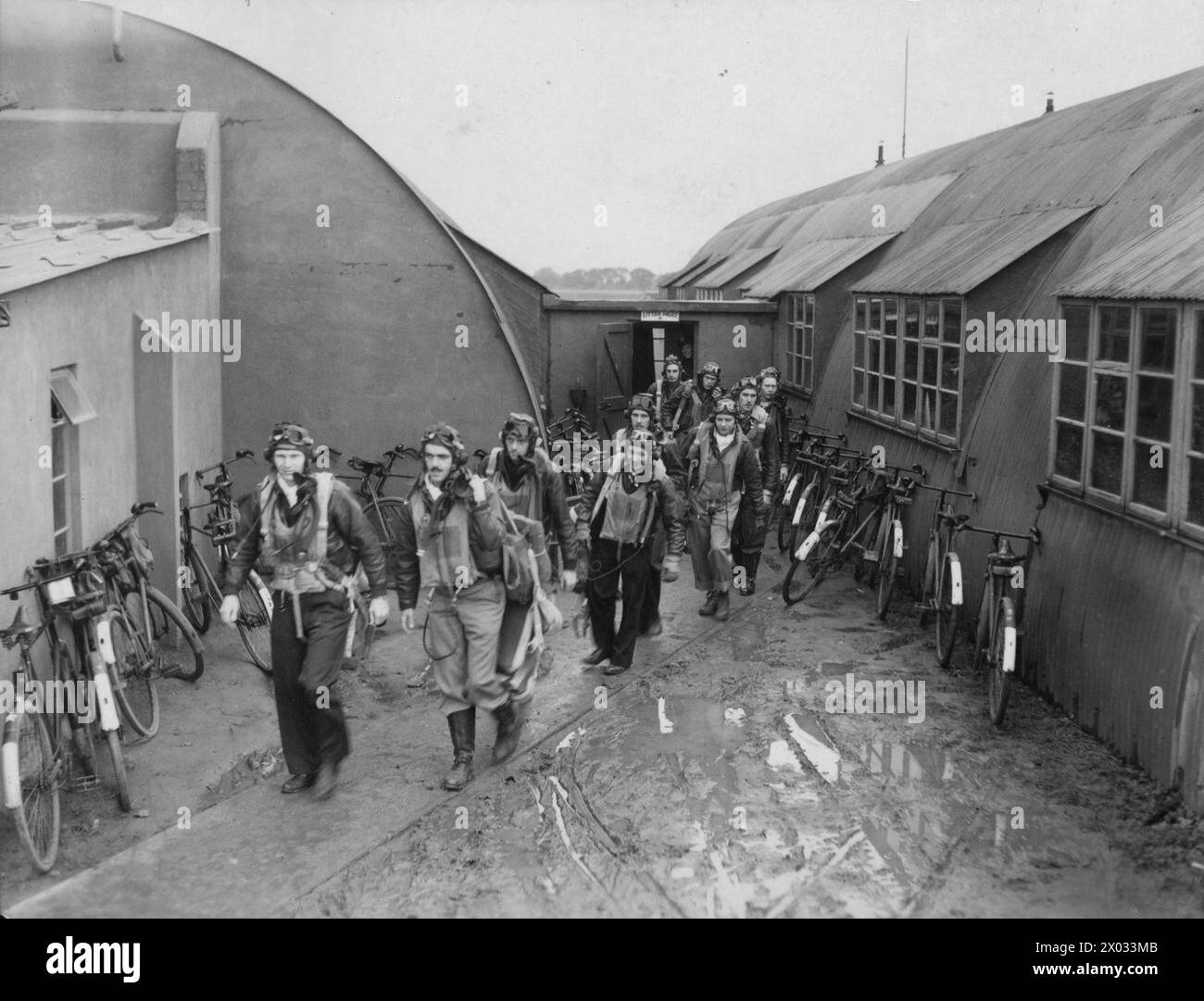 STATI UNITI OTTAVA FORZA AEREA IN GRAN BRETAGNA, 1942-1945 - i piloti del 353rd Fighter Group escono da una sala riunioni, oltrepassando le molte biciclette appoggiate contro le pareti degli edifici adiacenti. Questo fu probabilmente preso alla base aerea di Metfield, dove il gruppo era di stanza tra il 3 agosto 1943 e il 12 aprile 1944. Approvato per la pubblicazione il 29 ottobre 1943.didascalia stampata allegata ad altre stampe di questa serie: ''Thunderbolts from Britain'. Queste foto, scattate da Sam Goldstein, corrispondente di guerra per la piscina, in una base aerea dell'8th Fighter Command situata "da qualche parte in Inghilterra", mostrano i piloti di un Americ Foto Stock