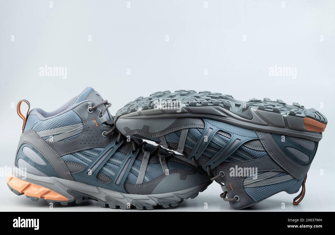 Un paio di scarpe da trekking grigie isolate sullo sfondo dello studio Foto Stock