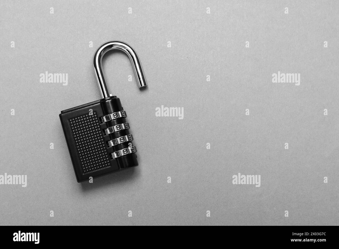 Un lucchetto a combinazione in acciaio su sfondo grigio, vista dall'alto. Spazio per il testo Foto Stock