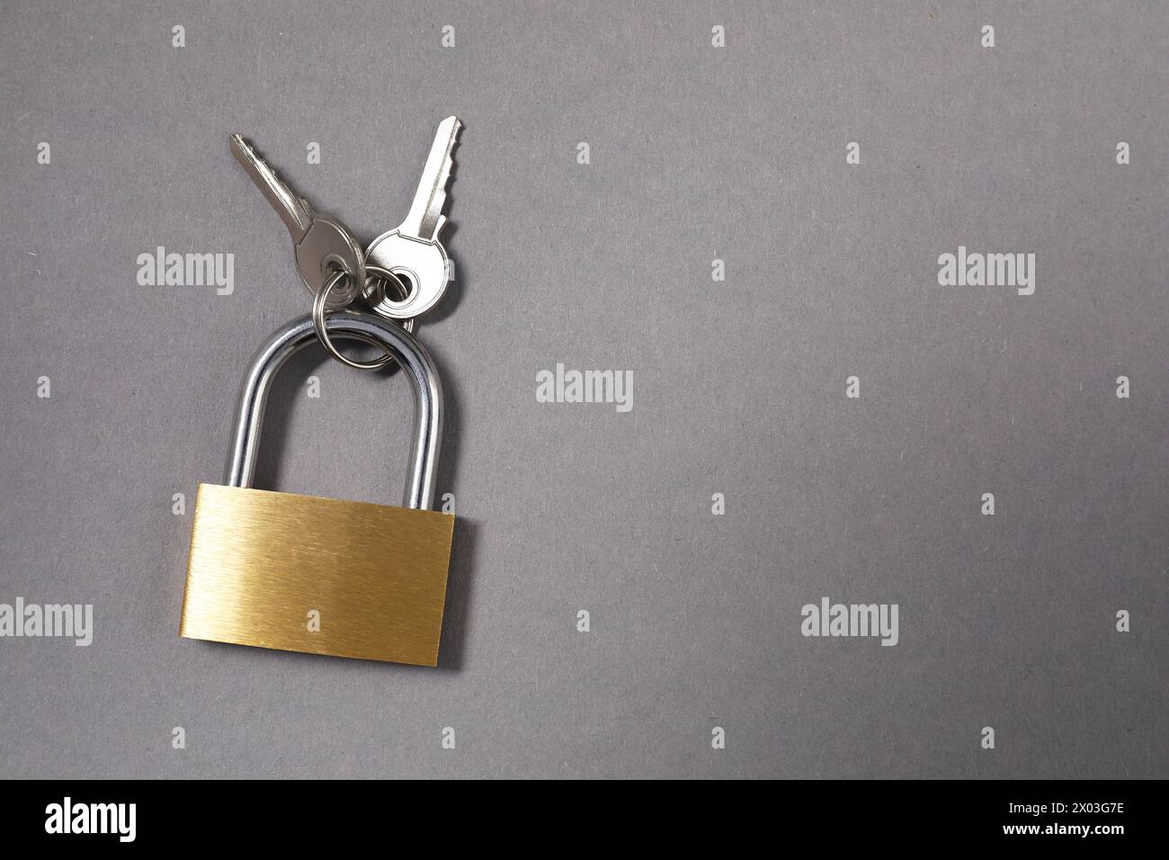 Lucchetto in acciaio con tasti su sfondo grigio, vista dall'alto. Spazio per il testo Foto Stock