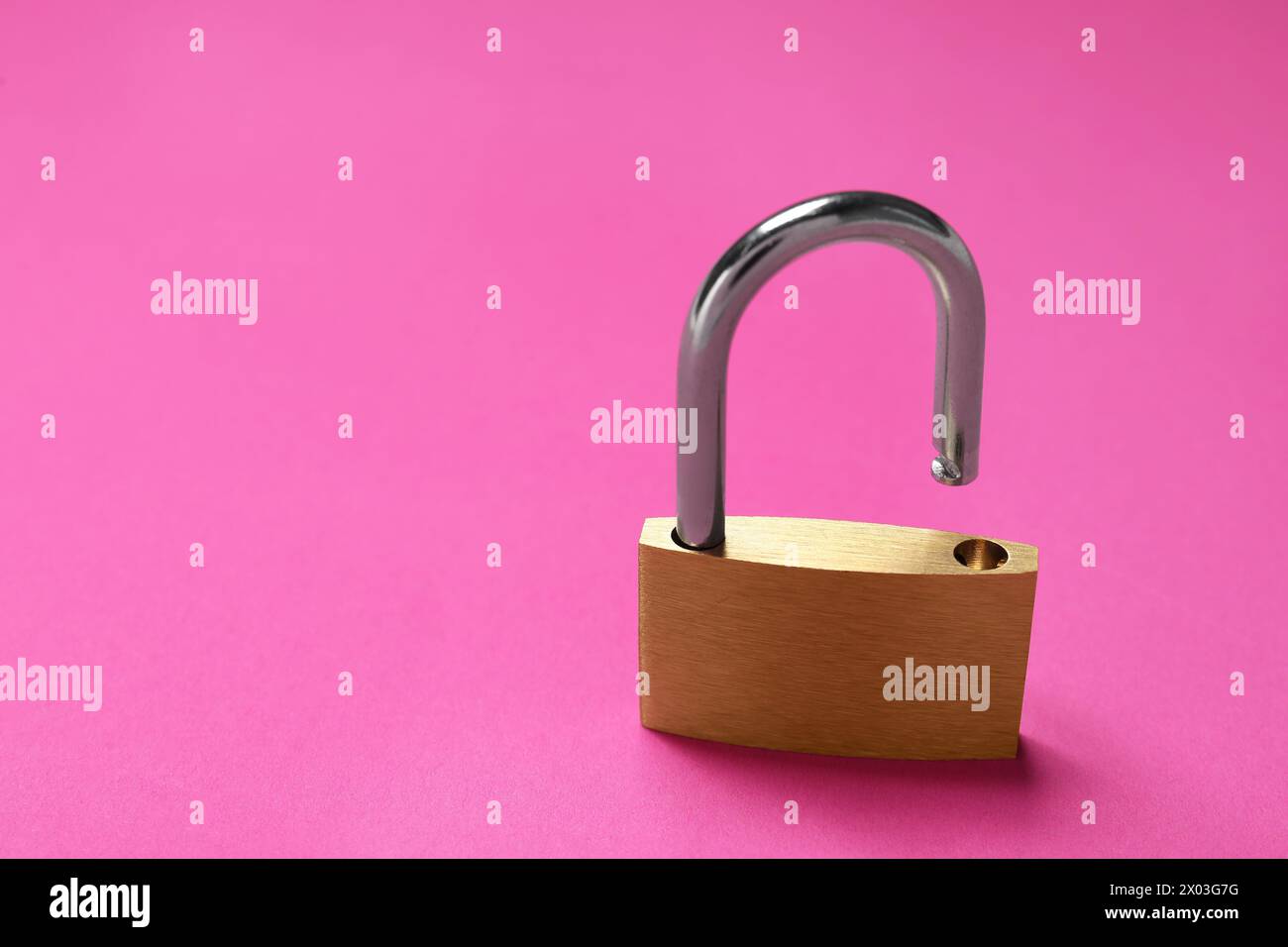 Un lucchetto in acciaio su sfondo rosa, primo piano. Spazio per il testo Foto Stock