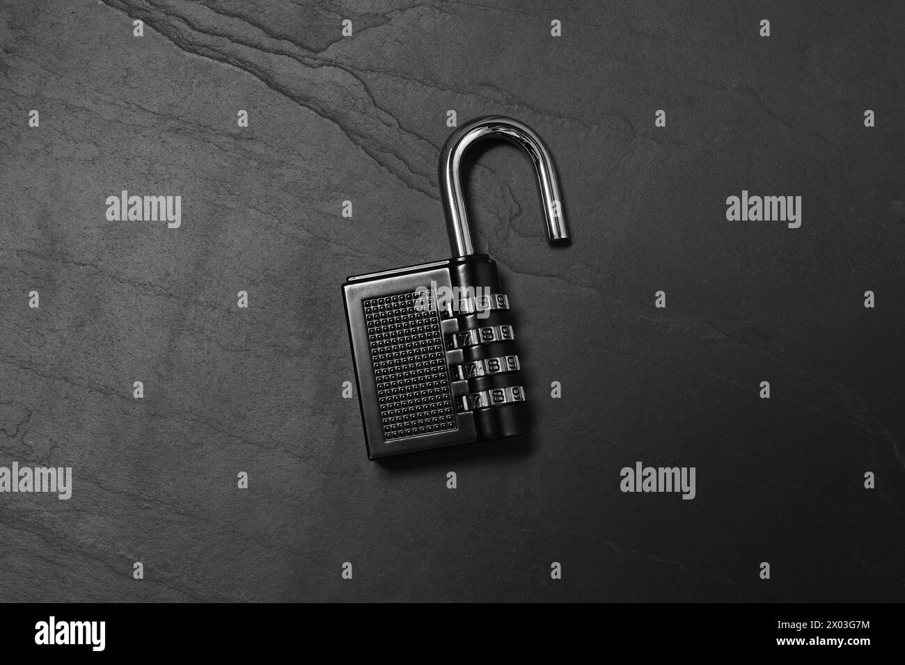 Un lucchetto a combinazione in acciaio sul tavolo nero, vista dall'alto Foto Stock
