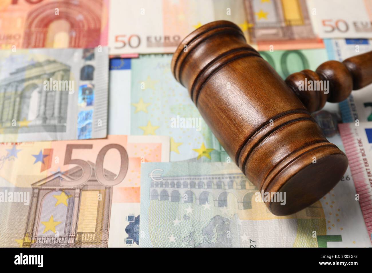 Legge fiscale. Martelletto di legno sulle banconote in euro, primo piano Foto Stock
