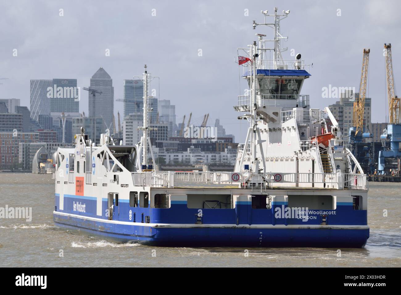 Woolwich Ferry BEN WOOLLACOTT addestramento dell'equipaggio sul Tamigi con lo skyline di Canary Wharf e la barriera del Tamigi sullo sfondo Foto Stock