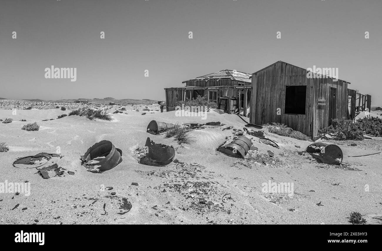 Casa abbandonata di minatori di legname con tamburi di olio di poldo nella sabbia in primo piano, preservata dall'aria secca del deserto, presso la miniera di Borgenfels nel Forbidde Foto Stock