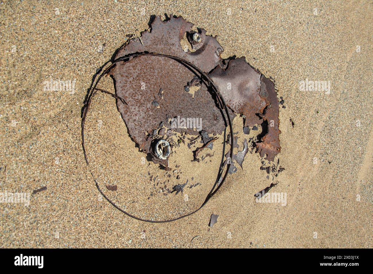 Vecchi e arrugginiti lavori in ferro nella sabbia dell'abbandonato nella vecchia città mineraria di Bogenfels, nel deserto della Namibia. Foto Stock