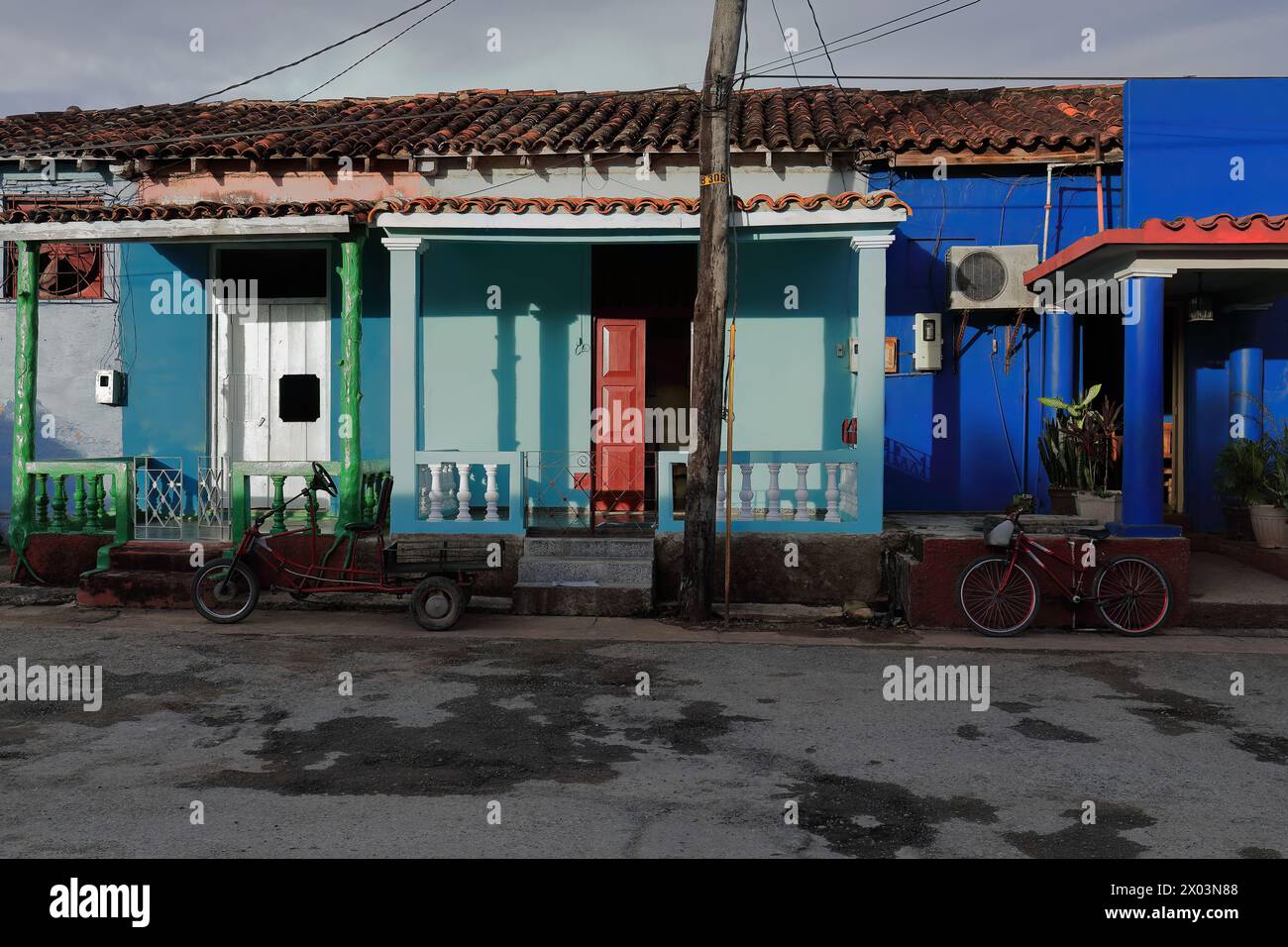 154 Portici di case vernacolari di fronte al tramonto con pareti dipinte di indaco, blu chiaro e blu zaffiro su Adela Azcuy Street. Viñales-Cuba. Foto Stock