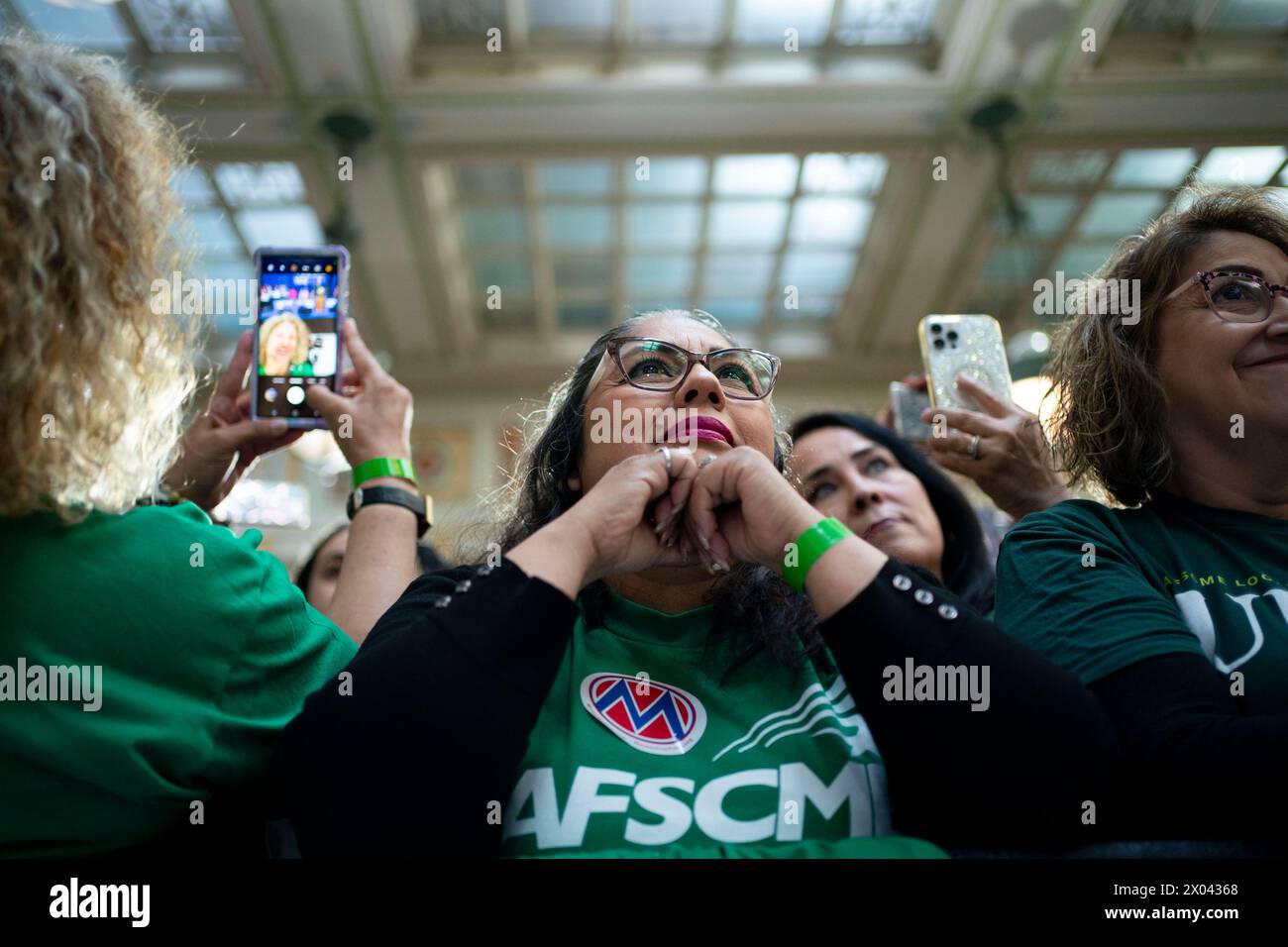 Washington, Stati Uniti. 09 aprile 2024. Una donna che indossa una camicia dei dipendenti della American Federation of State, County and Municipal si guarda mentre il presidente Joe Biden fa commenti sull'economia sanitaria durante un evento alla Union Station di Washington, DC, martedì 9 aprile 2024. Foto di Bonnie Cash/UPI credito: UPI/Alamy Live News Foto Stock