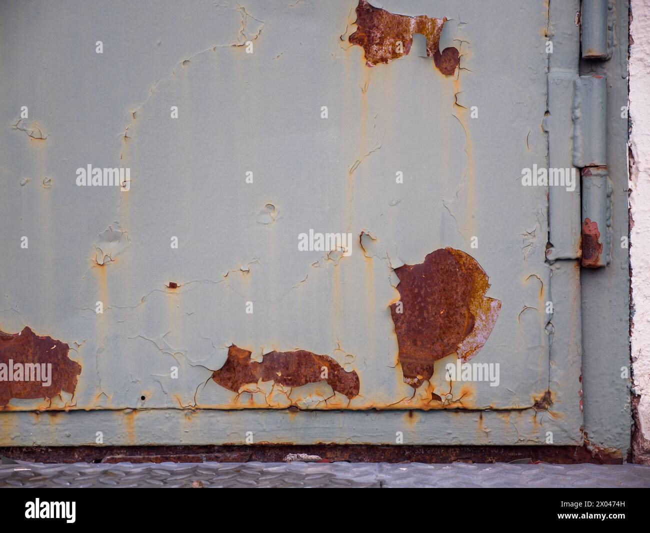 Primo piano di una vecchia porta in metallo verde pesante arrugginito Foto Stock