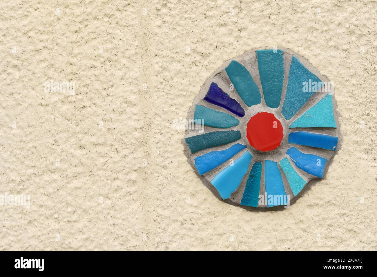 Un vibrante pezzo di vetro blu e rosso è attaccato al lato di un edificio, aggiungendo un tocco di colore e stile artistico al paesaggio urbano. Foto Stock