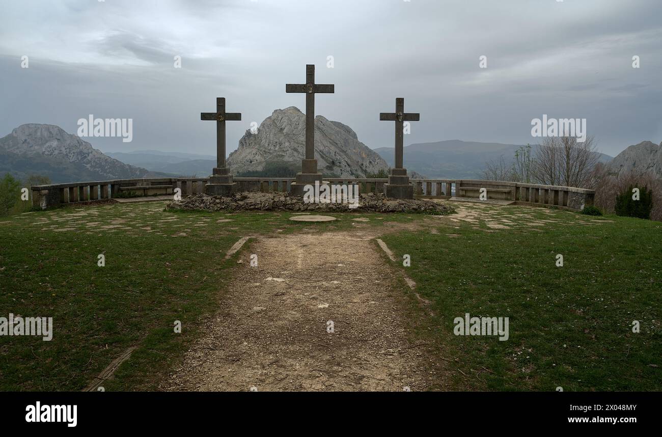 foto di una scultura religiosa in cui vengono viste tre grandi croci in un punto panoramico e sullo sfondo si possono vedere alcune montagne, tutte circondate da un'area di Foto Stock