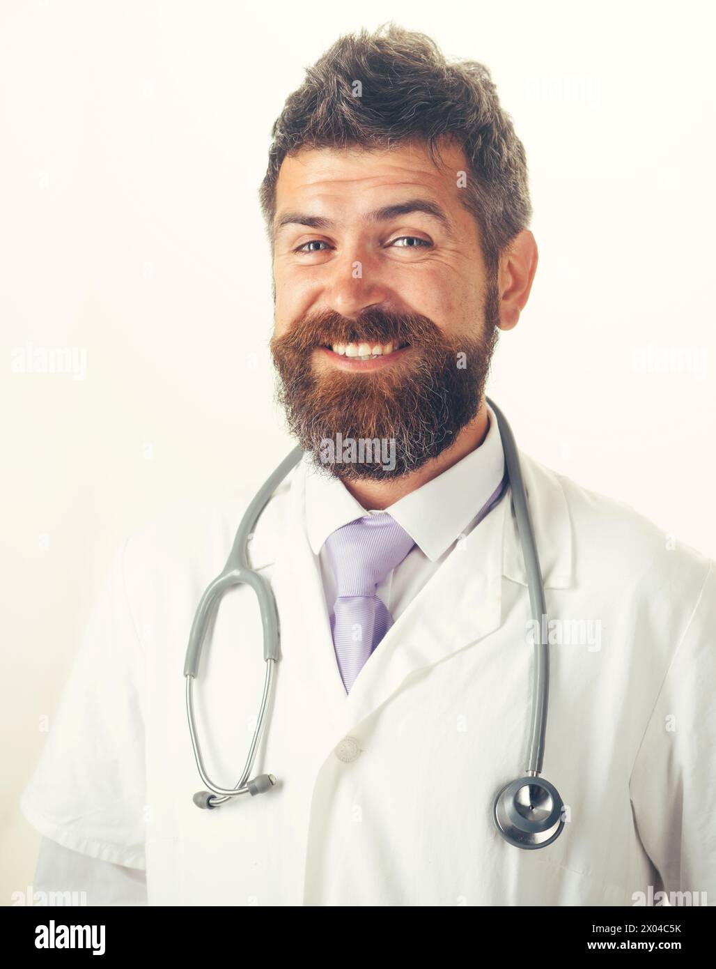 Concetto di assistenza sanitaria, trattamento e personale medico. Ritratto di uomo sorridente medico in abito medico con stetoscopio sul collo. Bella amica barba Foto Stock