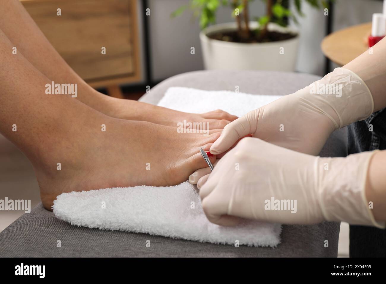 Pedicurista che taglia le unghie dei piedi del cliente con le forbici in salone di bellezza, primo piano Foto Stock