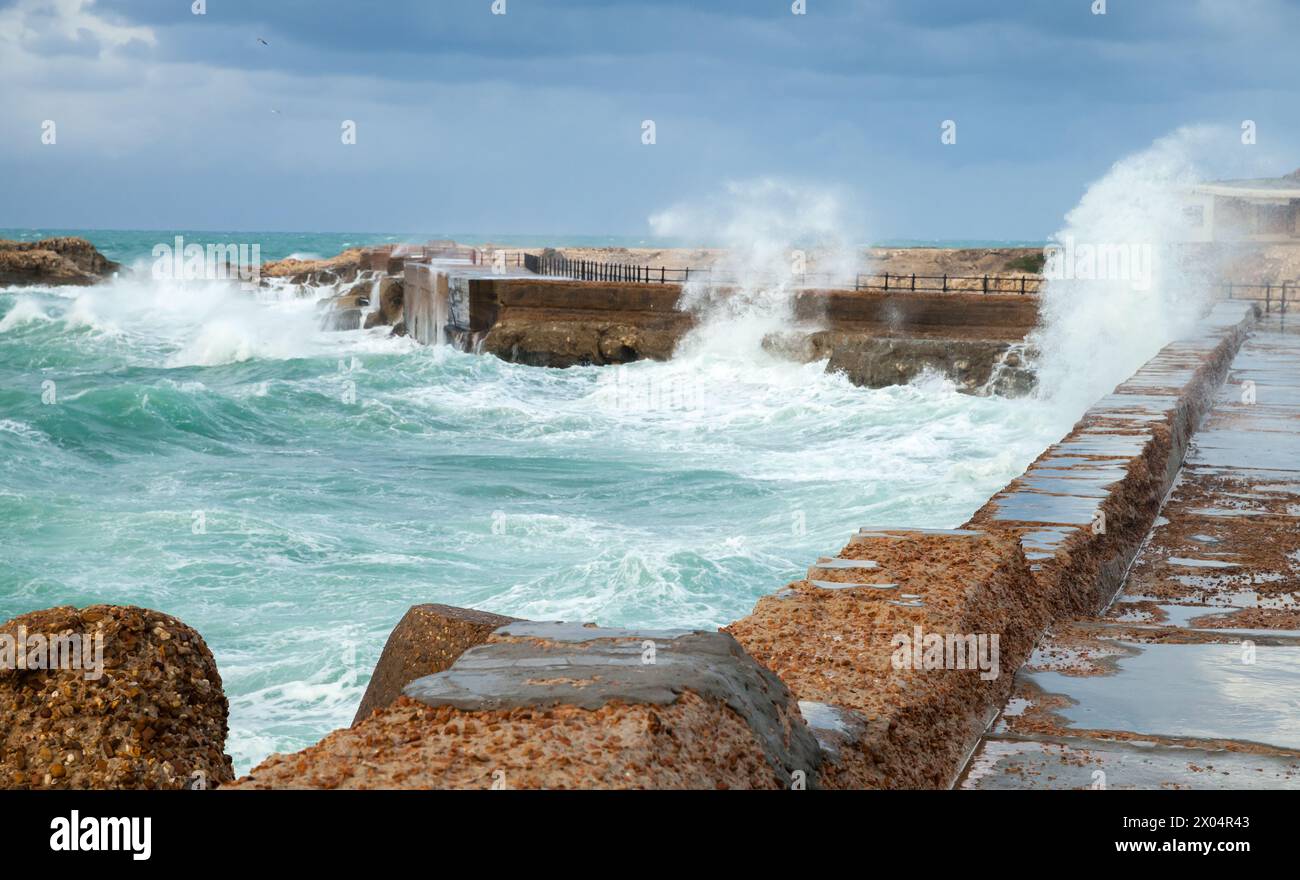 Paesaggio costiero con fortificazioni costiere in pietra e onde infranti. Alessandria, Egitto Foto Stock