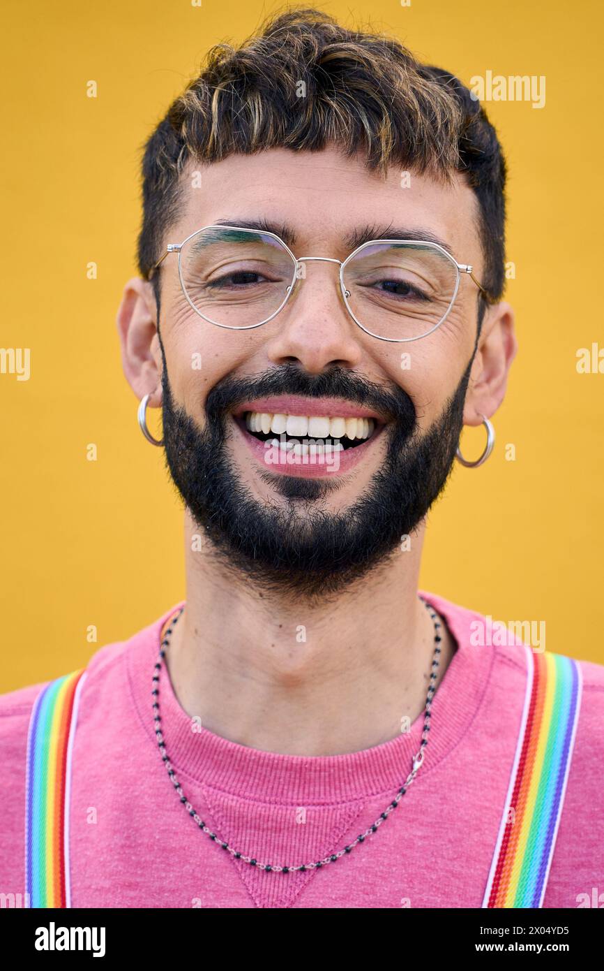 Primo piano sorridente giovane Caucasico con bretelle lgbt arcobaleno. Generazione z. Foto Stock