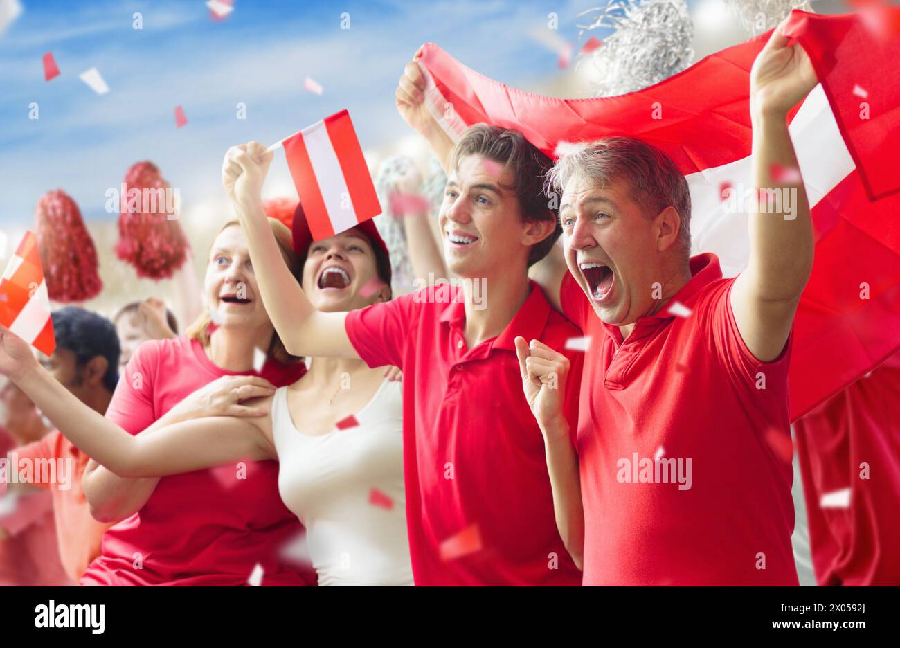 Tifoso austriaco nello stadio. Tifosi austriaci sul campo di calcio che guardano le partite della squadra. Gruppo di sostenitori con bandiera e jerseyfo nazionale Foto Stock