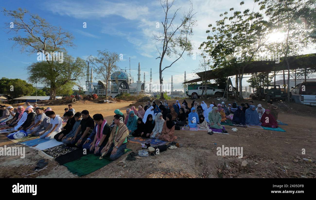Zamboanga City, Filippine. 10 aprile 2024. Fedeli musulmani che eseguono Eid Salah fuori dalla grande Moschea di Sadik. La costruzione della grande Moschea di Sadik è in corso e, una volta completato, il complesso di 50 ettari sarà la più grande moschea delle Filippine. (Immagine di credito: © Sherbien Dacalanio/Alamy Live News) Foto Stock