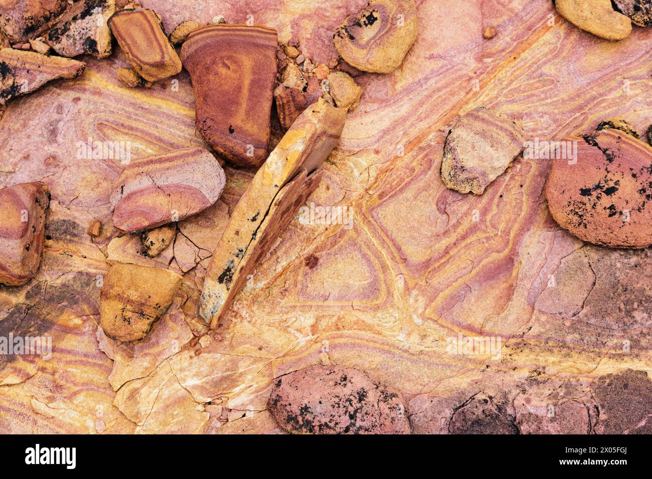 rocce di arenaria dai colori vivaci sotto la pioggia con striature e crepe Foto Stock