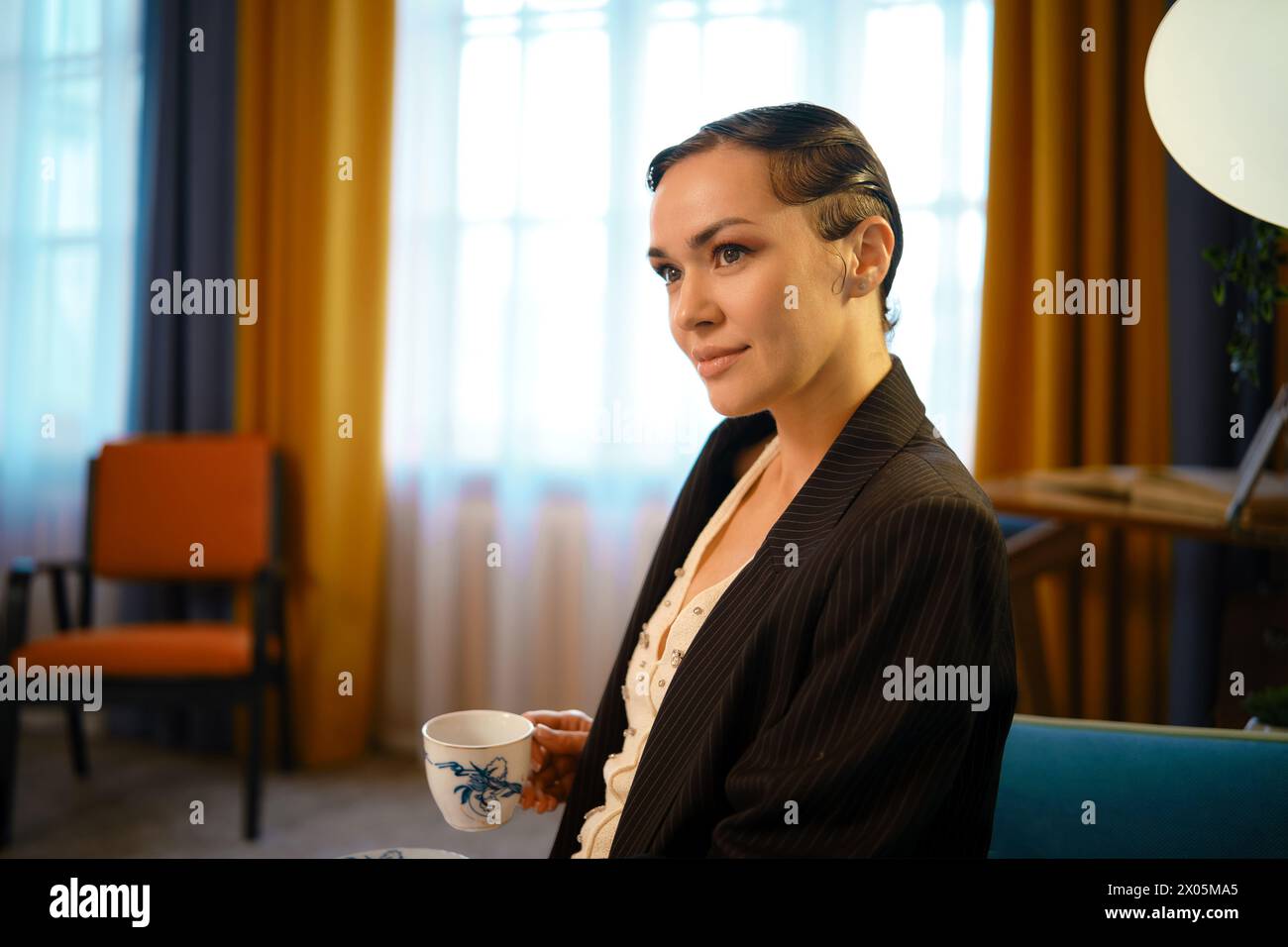 Ritratto di una donna elegante e adorabile con un'acconciatura vecchia che tiene in mano una tazza di tè Foto Stock