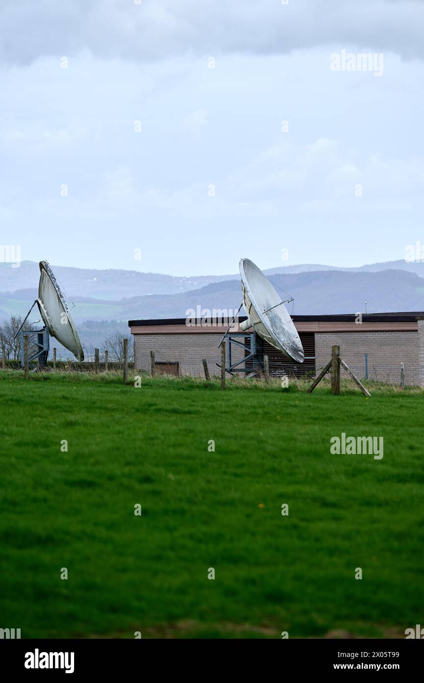 Due vecchie parabole satellitari in campo verde in Inghilterra Foto Stock Due vecchie parabole satellitari in campo verde in Inghilterra Foto Stock