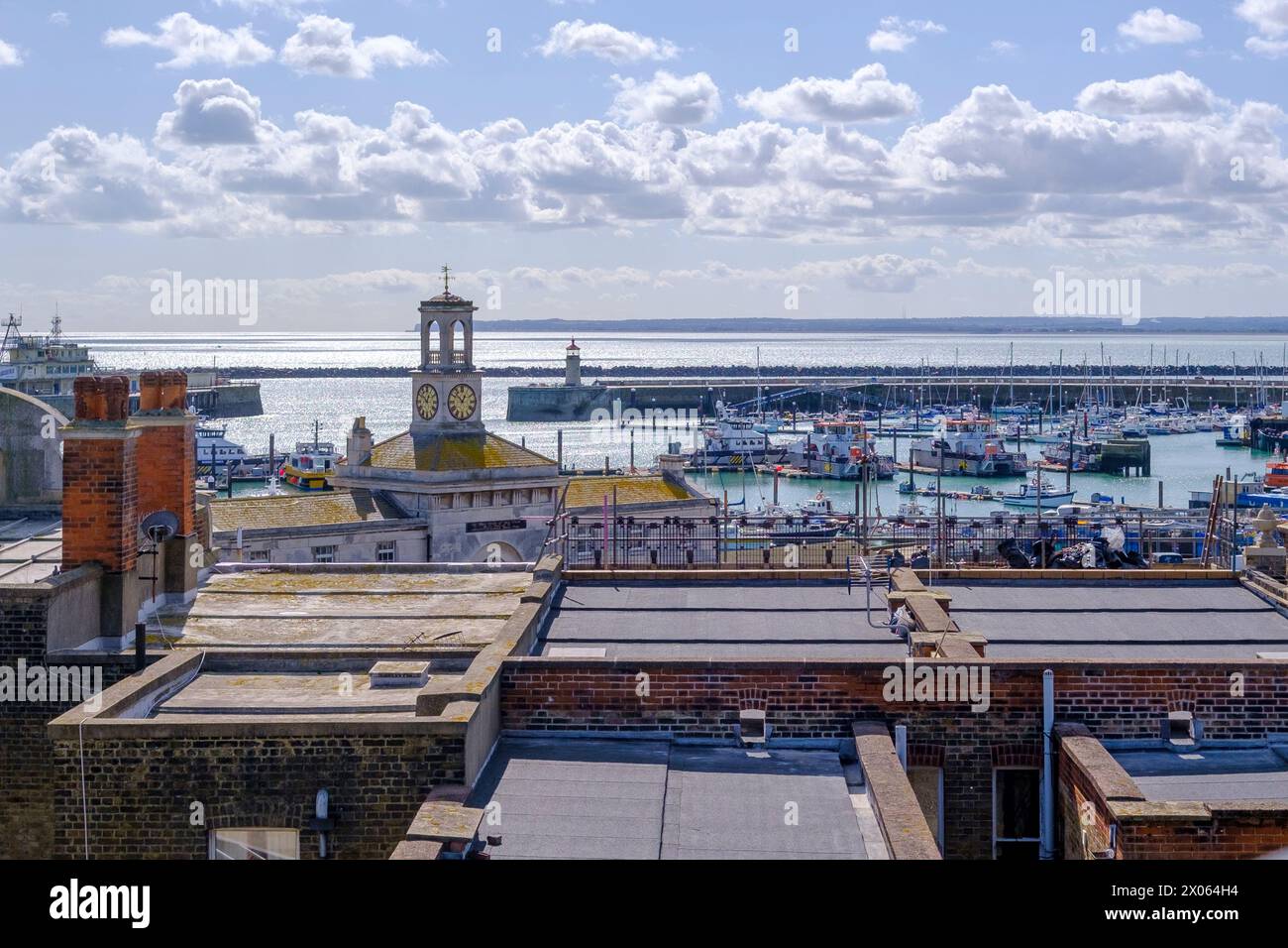 Affacciato sul mare al Ramsgate Royal Harbour con l'edificio Clock House, il molo ovest, la casa faro e le barche ormeggiate. Foto Stock