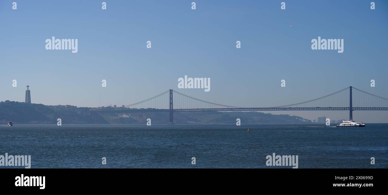 Vista panoramica del Ponte De Abril del 25 e del Santuario del Cristo Re a Lisbona, Portogallo, in una giornata limpida Foto Stock