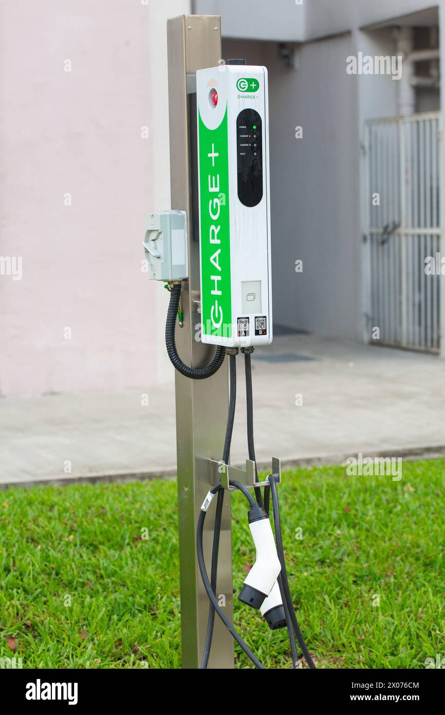 Punto di ricarica e prese EV, gestiti da Charge+ Pte Ltd a Singapore. Foto Stock