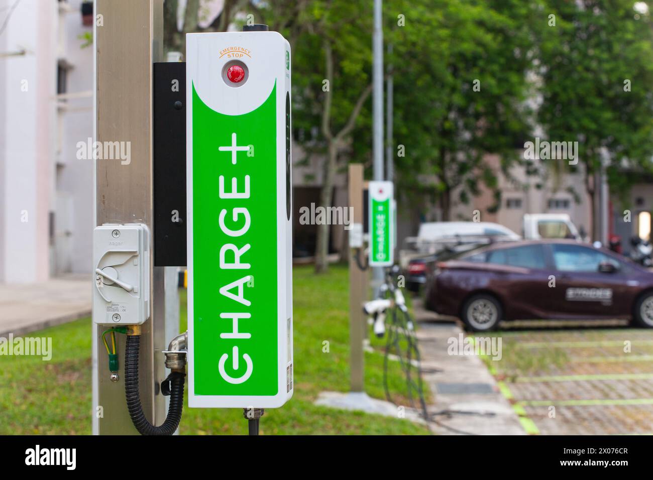 Caricabatterie EV per veicoli elettrici pubblici in un'area parcheggio all'aperto, gestito da Charge+ Pte Ltd a Singapore. Foto Stock
