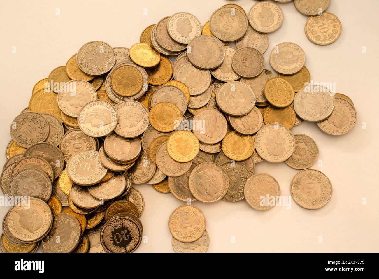 Pile di monete di diverse dimensioni stese sul tavolo prima di essere contate. Soldi svizzeri. Foto Stock