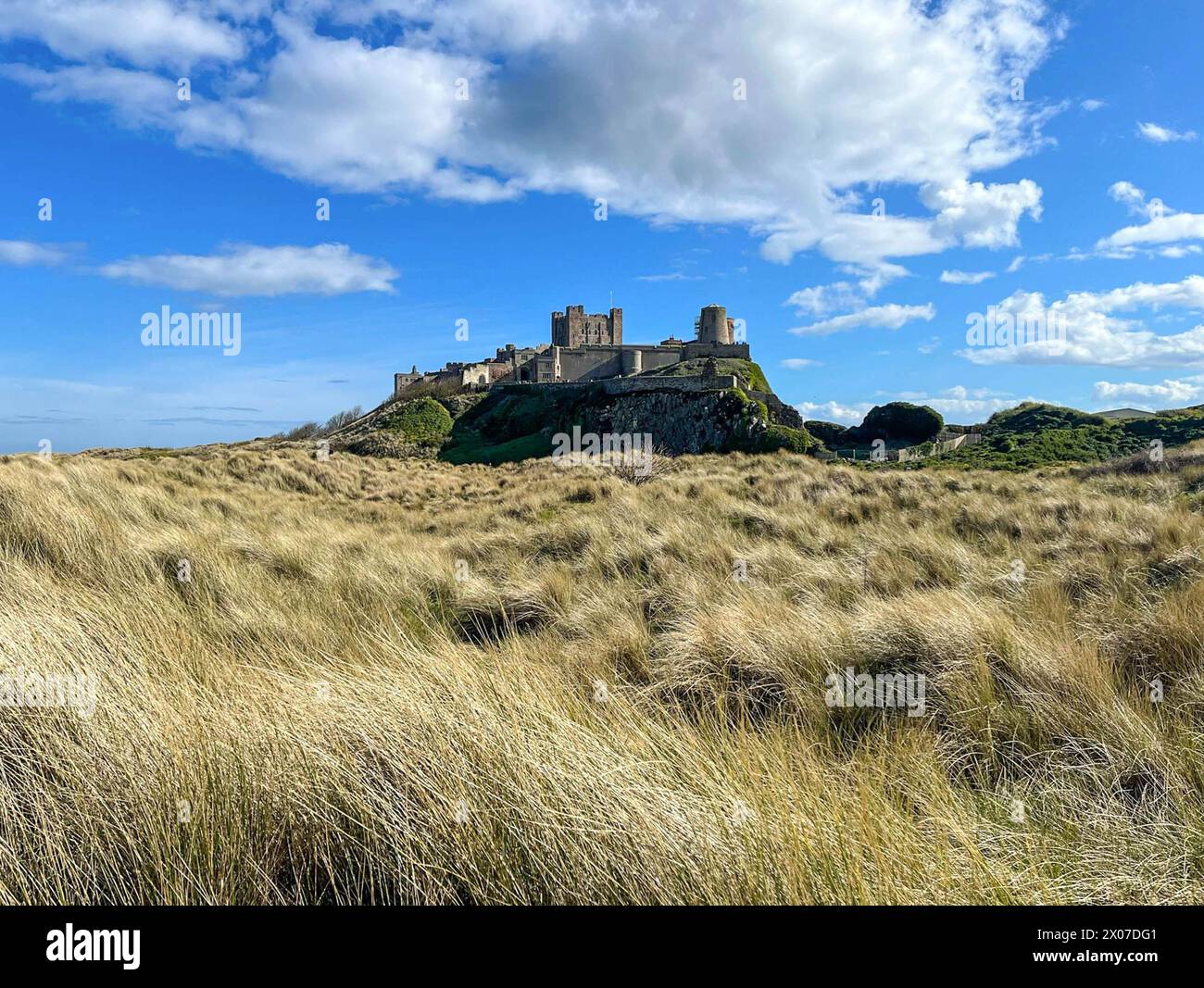 Castello di Bamburgh e dune di sabbia sulla spiaggia, Northumberland Foto Stock