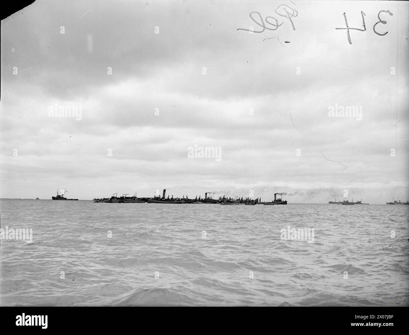 Dal 6 all'8 giugno, a bordo della HMS Aristocrat, i porti prefabbricati di Mulberry furono trasportati attraverso il Canale della Manica e sbarcati ad Arromanches per supportare le operazioni. Sezioni della struttura della "balena" sono state trainate in posizione. Foto Stock
