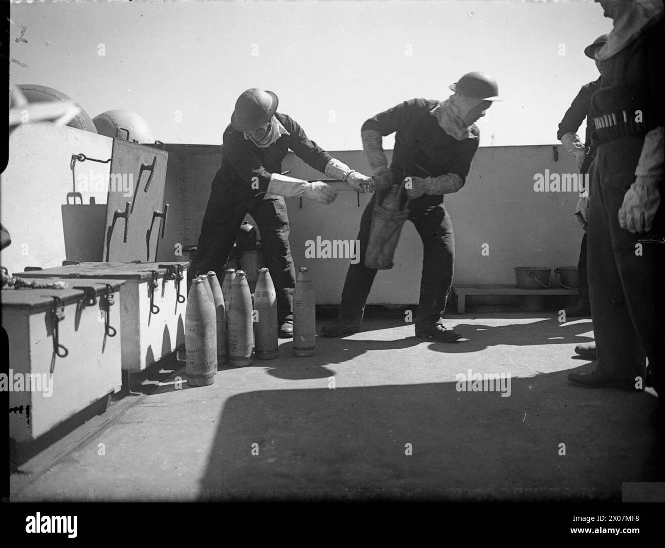 LA ROYAL NAVY DURANTE LA SECONDA GUERRA MONDIALE - passando proiettili da 4,7 pollici attraverso la botola di una pistola per imbarcazioni da sbarco (grande) (LCG(L)) durante una prova d'invasione al largo dell'isola di Wight. Si noti che l'equipaggio indossa abiti anti-flash Foto Stock