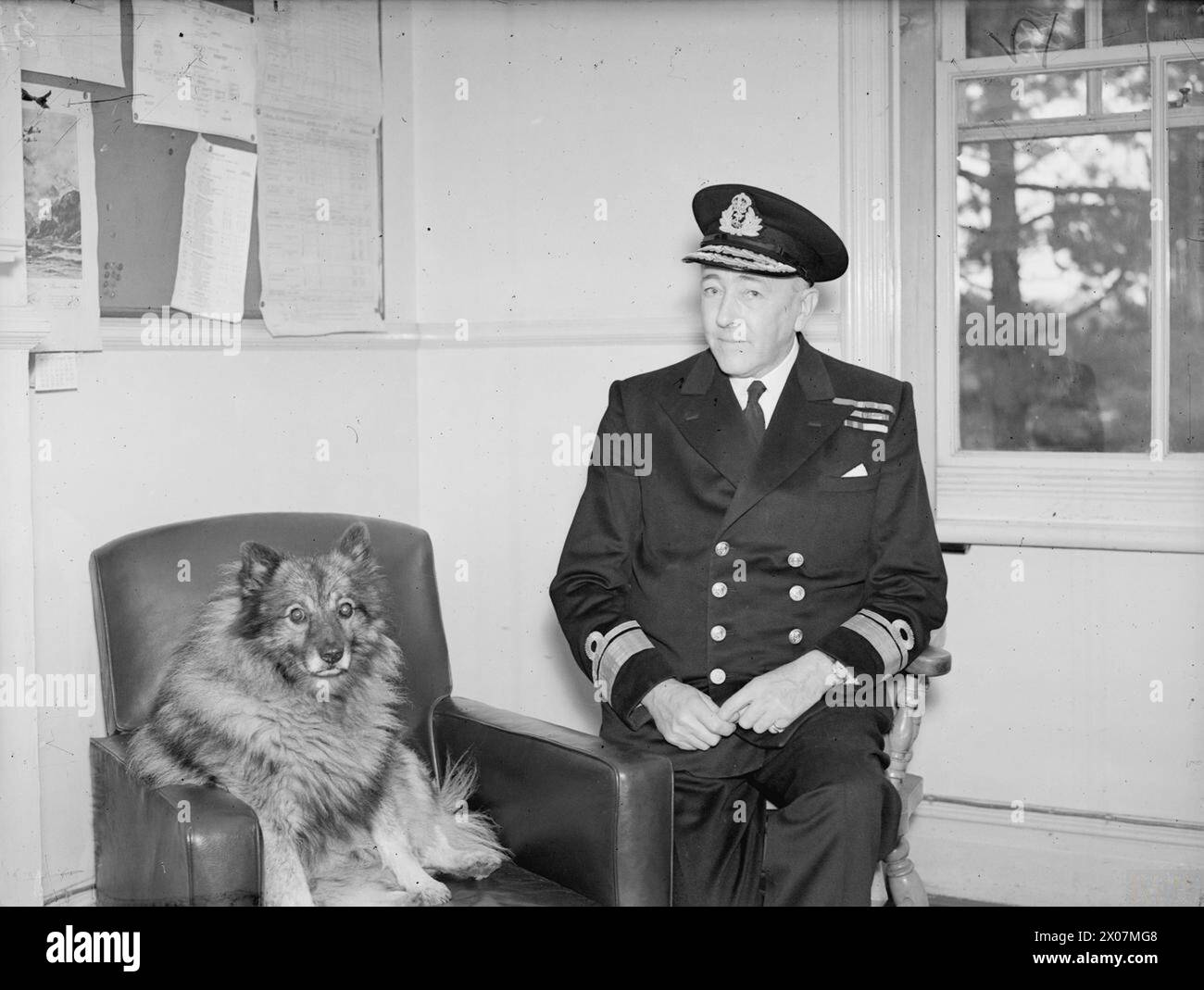 Tra il 13-17 settembre 1943, alla Royal Naval Air Station Lee-on-Solent, il contrammiraglio C V Robinson, CB, era presente con la sua mascotte cane alla Fleet Air Arm Station. Foto Stock