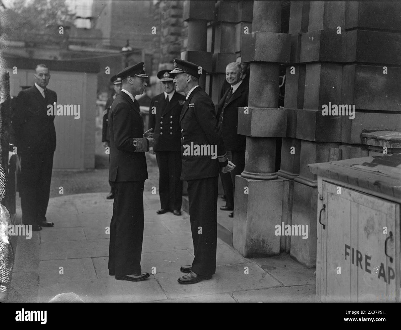 Il re incontrò Alexander, primo Lord dell'Ammiragliato, e Sir Dudley Pound, Ammiraglio della flotta, mentre parlava con il contrammiraglio A M Peters. Foto Stock